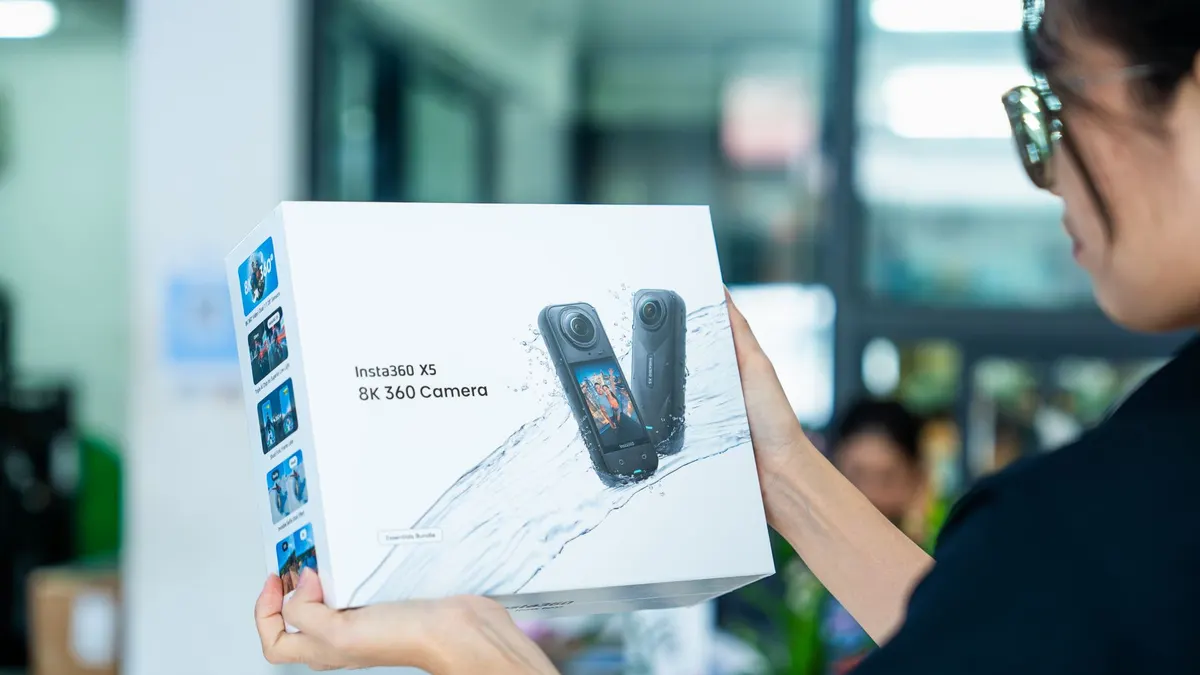 Close-up of person unboxing Insta360 X5 8K 360 Camera in an indoor setting.