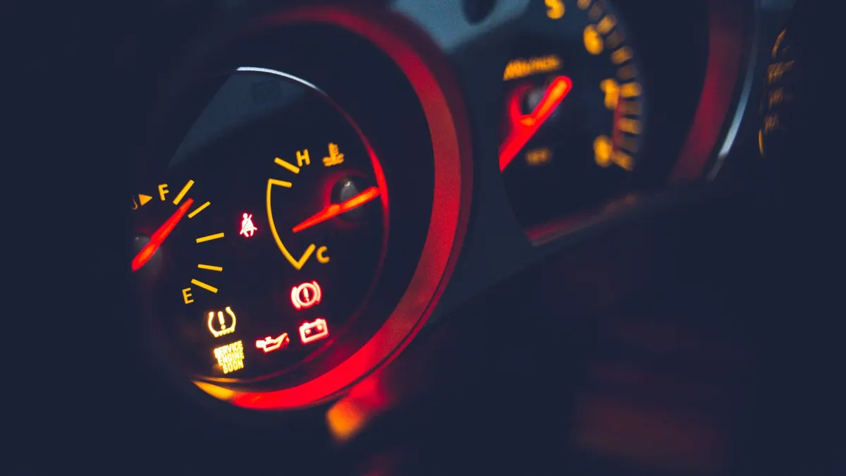Closeup of oil pressure gauge with arrows and scale on instrument panel in modern auto