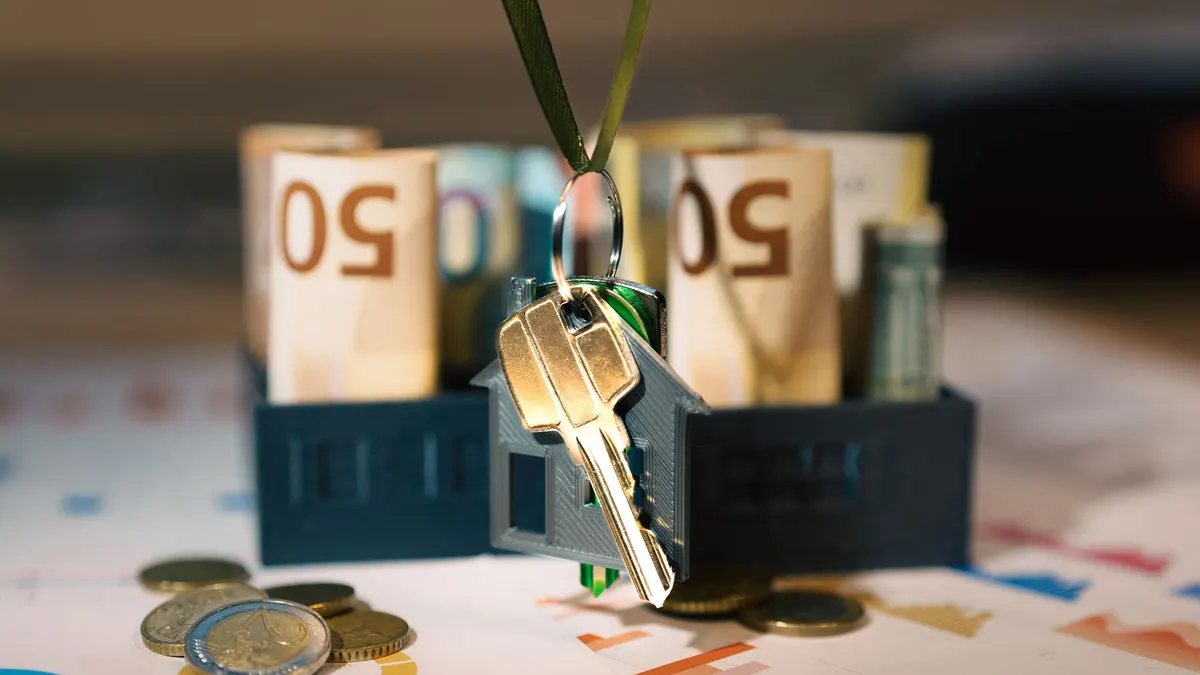 Keys hanging with money and charts, symbolizing real estate investment and financial planning.