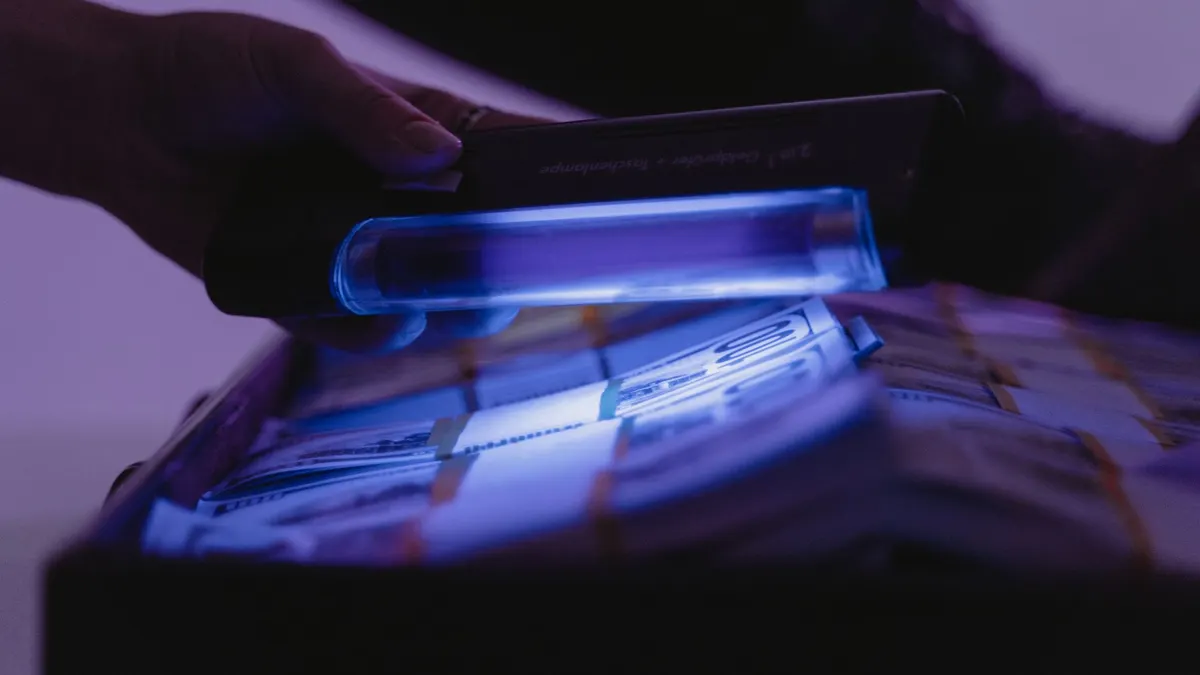 A close-up shot of banknotes under UV light to verify currency authenticity and detect counterfeits.