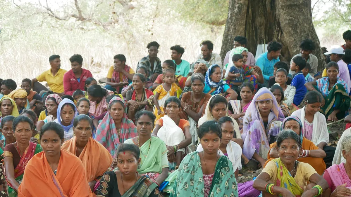 A large group of people sitting outdoors under a tree, showcasing diversity and unity.