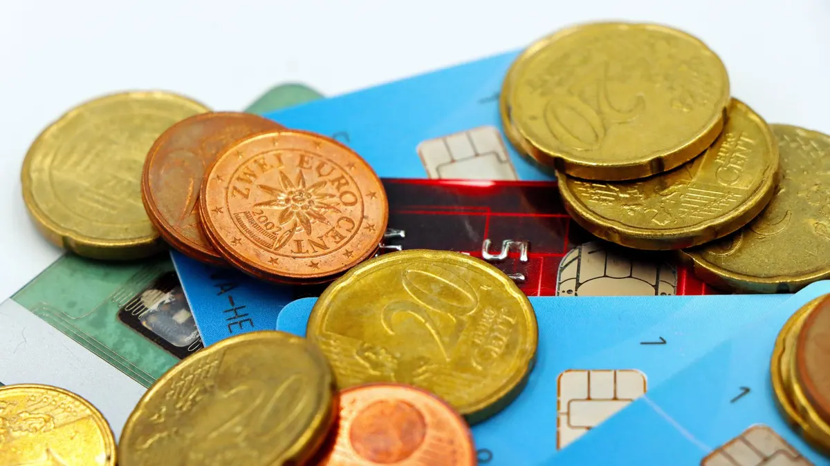 Close-up image of Euro coins and credit cards representing modern financial transactions.