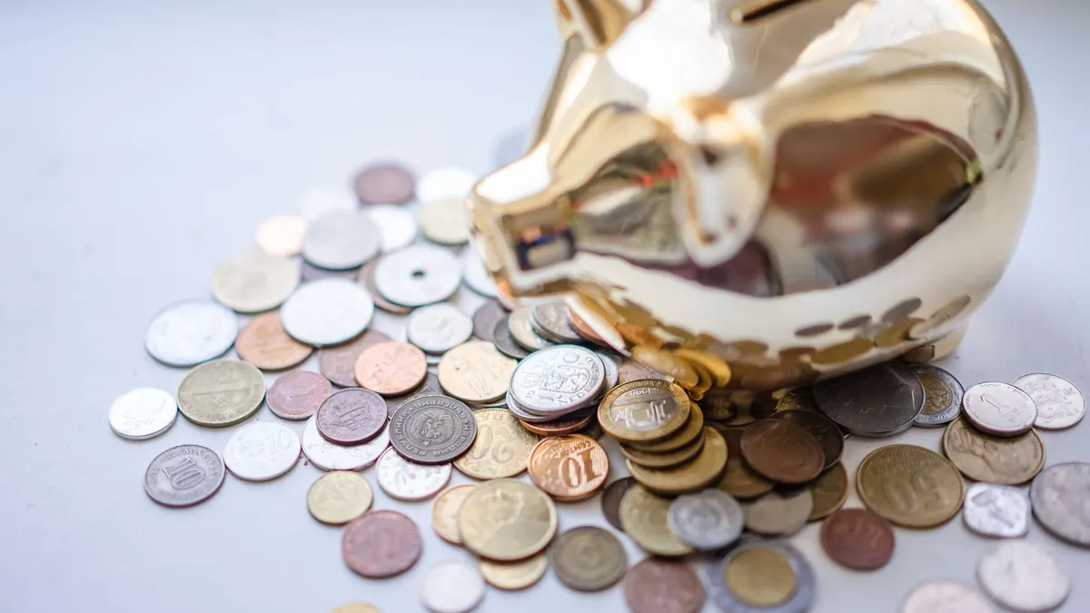 A golden piggy bank surrounded by assorted coins, symbolizing savings and wealth.