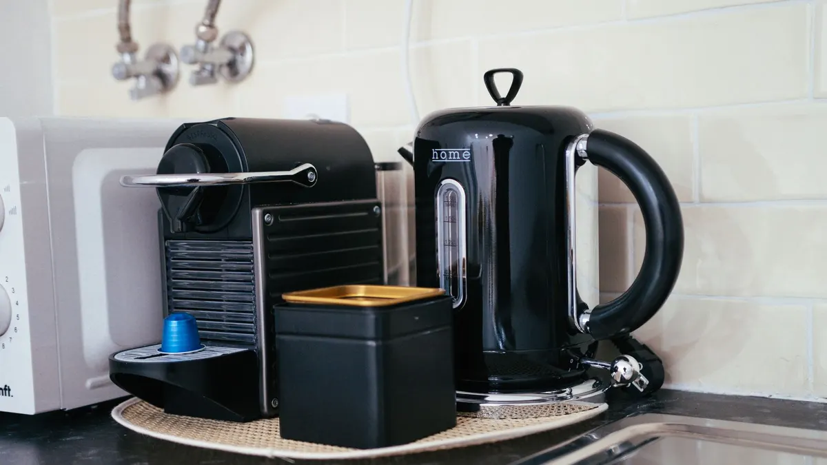 Sleek black coffee maker and kettle on a modern kitchen countertop, ideal for brewing.