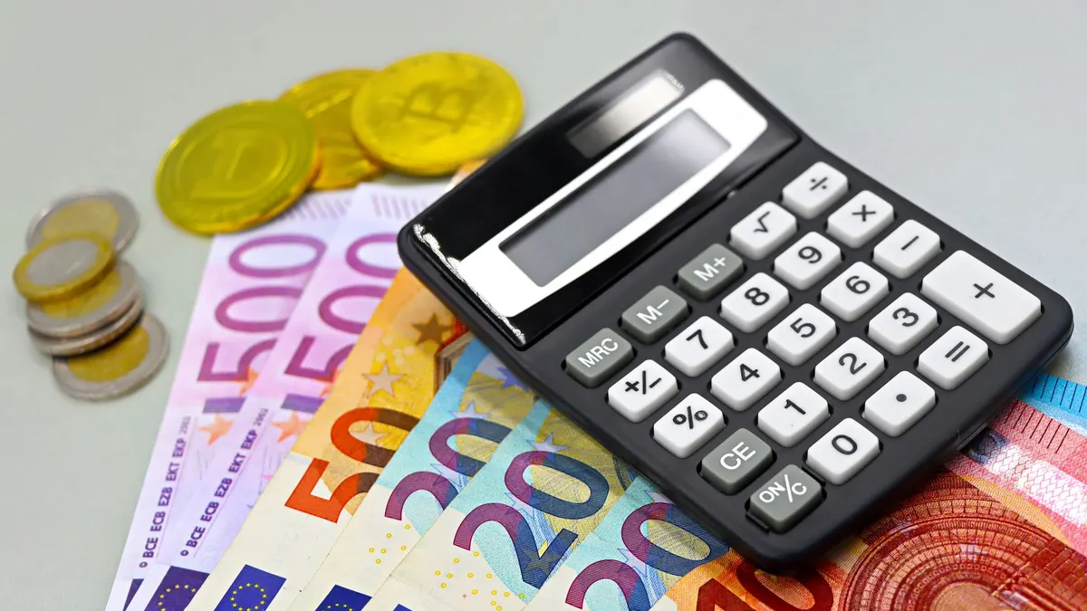 Image of euro banknotes, coins, and a calculator for financial planning. Perfect for finance themes.