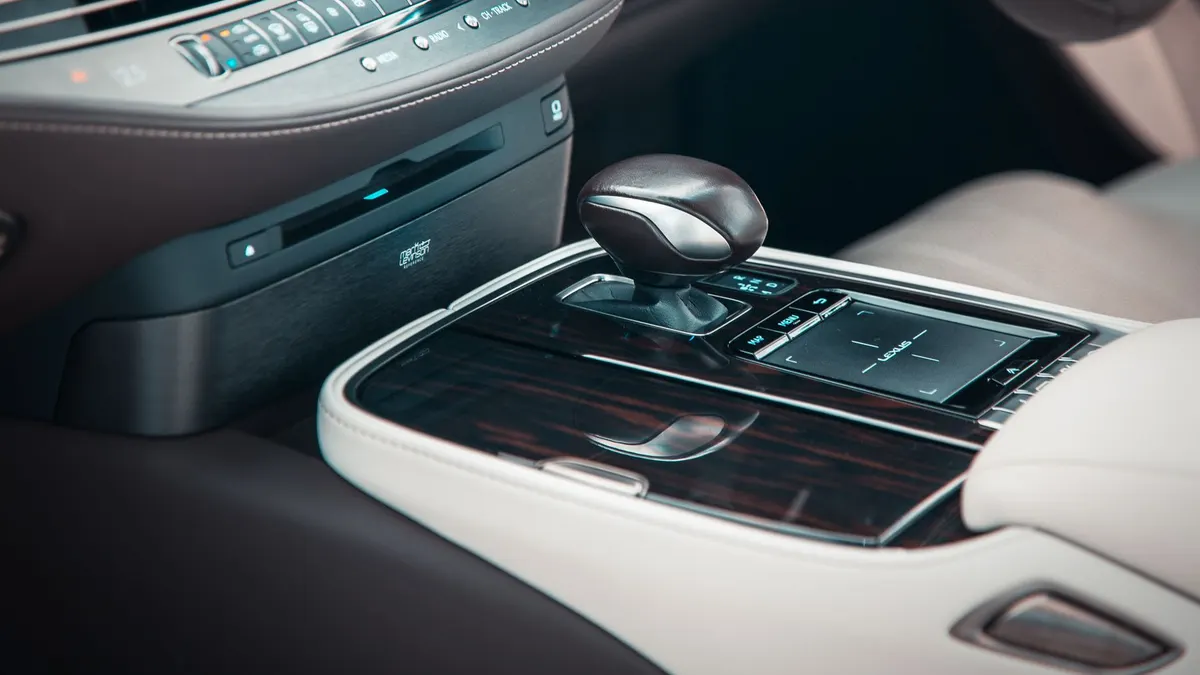Detailed view of a premium car interior featuring a gear shift and polished wooden trim.