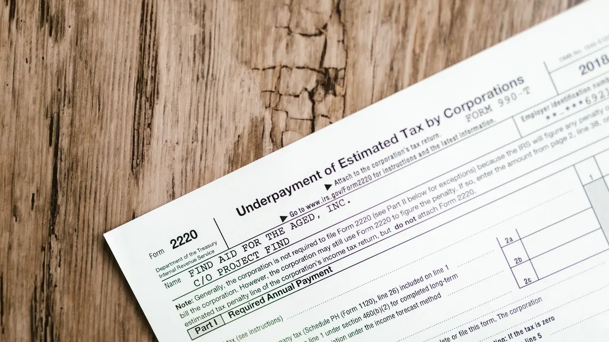 Close-up of a corporate tax form on a textured wooden surface, highlighting document details.