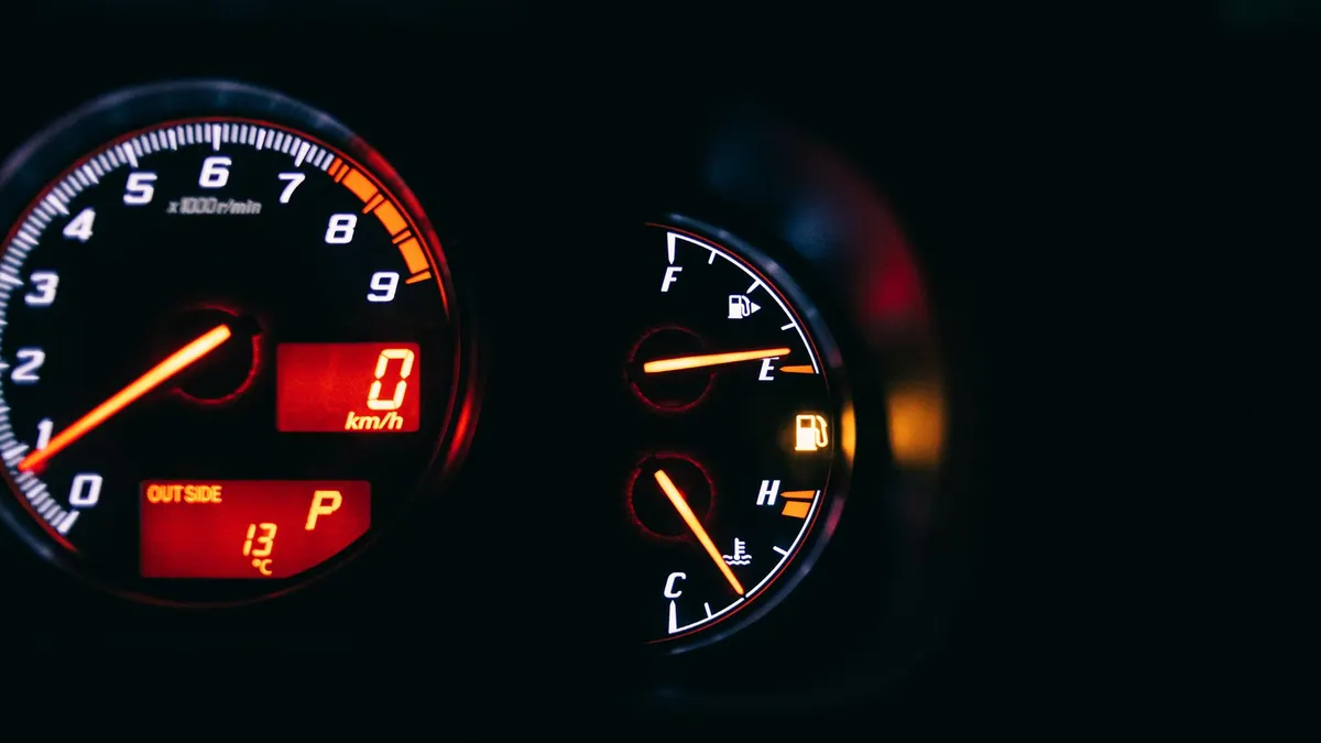 Modern control and measuring devices with arrows indicating numbers and letters on scales in automobile on black background