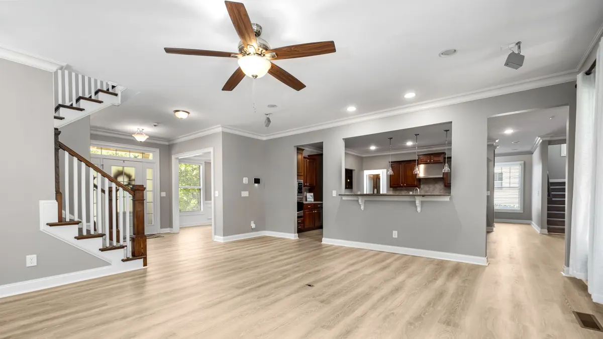 Spacious and modern open-plan living room with wooden flooring and staircase, ideal for home inspiration.