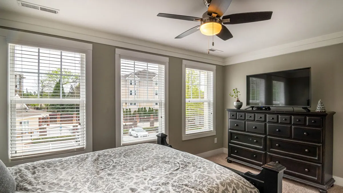 Spacious bedroom featuring elegant decor, modern furniture, and abundant natural light.